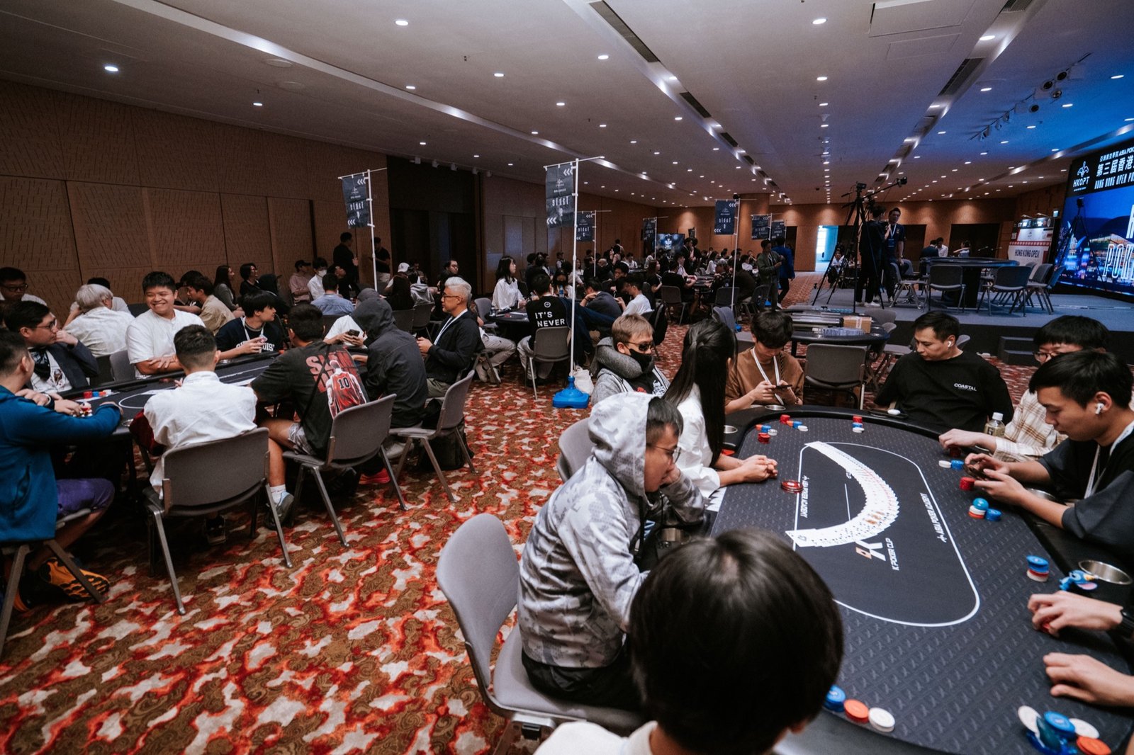 2025 香港撲克公開賽現場，多張牌桌延伸至主舞台